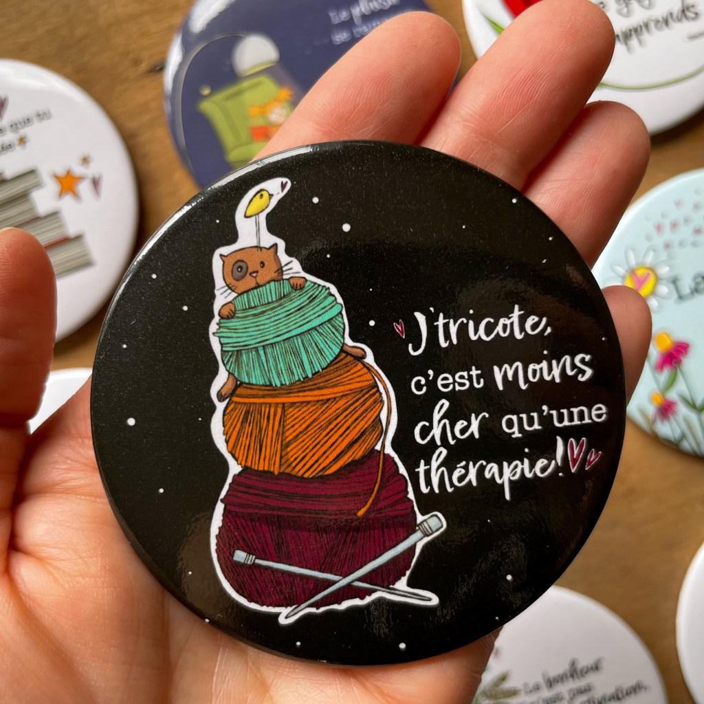 Aimant rond 3 pouces avec le dessin d'un chat et d'un oiseau derrière des balles de laines et l'inscription:" J'tricote, c'est moins cher qu'une thérapie".